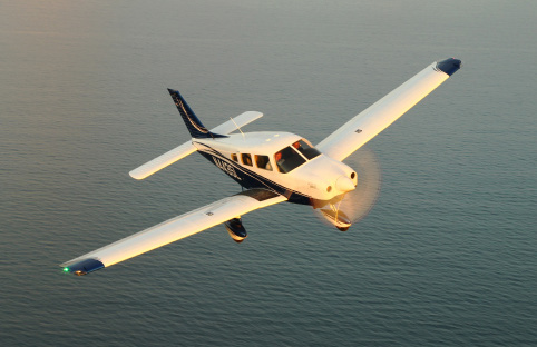 piper archer lx flying over the water