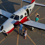 Thumbnail of a family loads their luggage onto a small private plane