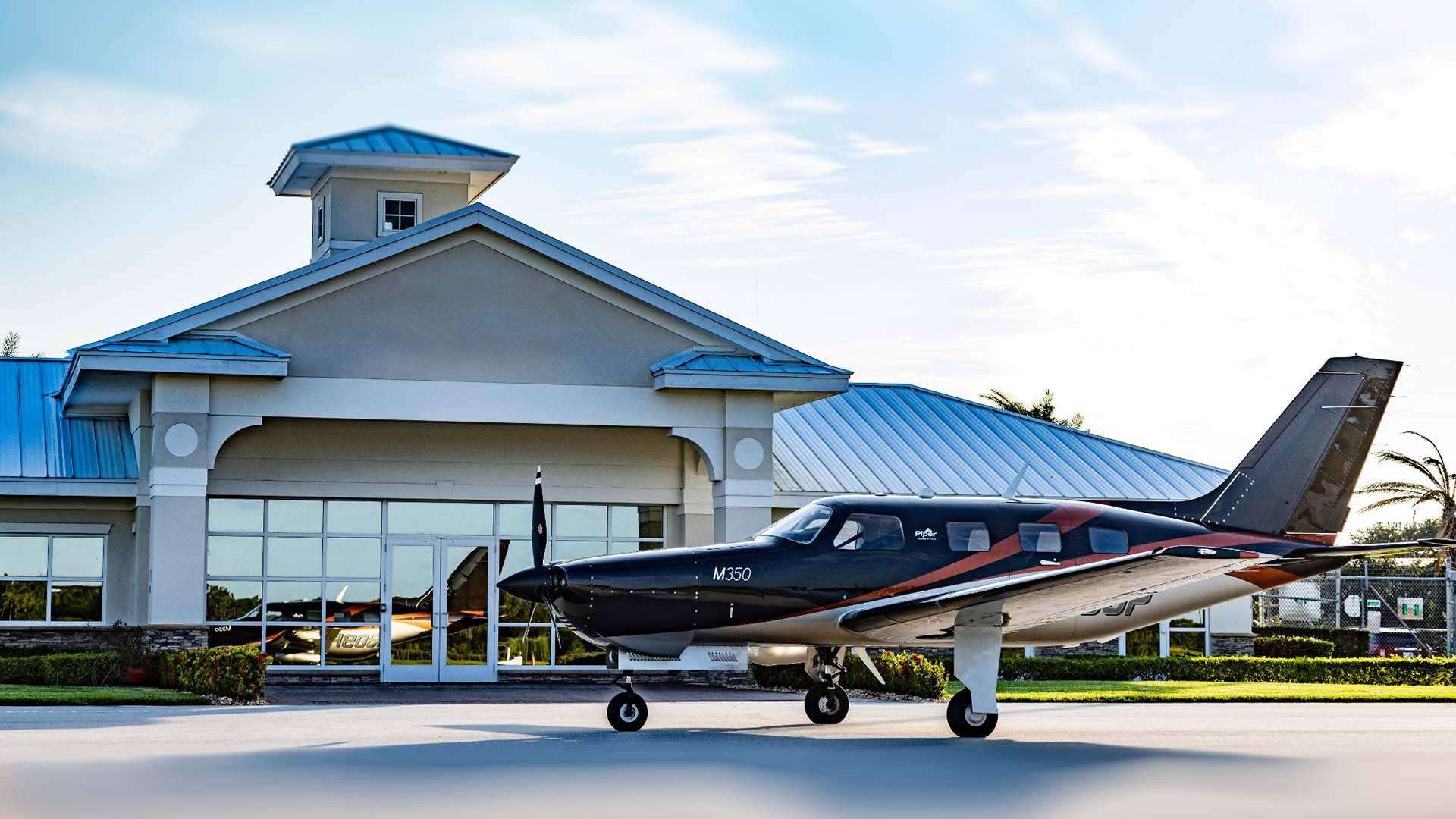 Artboard 17 piper airplane sitting outside an office